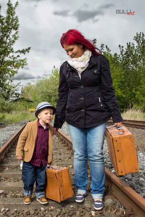 Frau und Kind mit Koffern im Freien